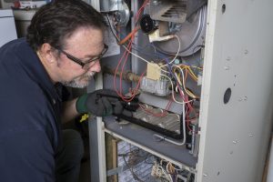 technician-examines-gas-furnace