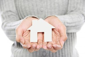 portrait-of-hands-holding-white-paper-house